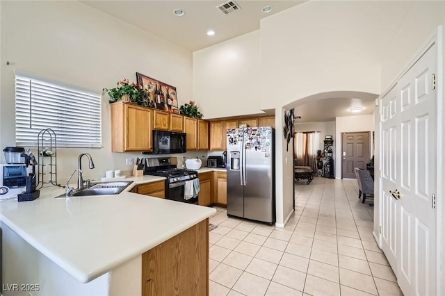 3642 Winter Whitetail St, Las Vegas, NV 89122 - kitchen with appliances with stainless steel finishes, arched walkways, a sink, light tile patterned floors, and light countertops