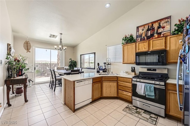 3642 Winter Whitetail St, Las Vegas, NV 89122 - kitchen with appliances with stainless steel finishes, a peninsula, a chandelier, light countertops, and lofted ceiling