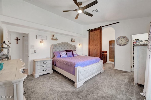 5725 N Durango Dr, Las Vegas, NV 89149 - carpeted bedroom with a barn door, ensuite bathroom, ceiling fan, lofted ceiling, and baseboards
