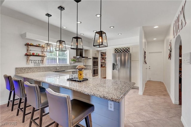 5725 N Durango Dr, Las Vegas, NV 89149 - kitchen with stainless steel appliances, a kitchen bar, a peninsula, open shelves, and recessed lighting