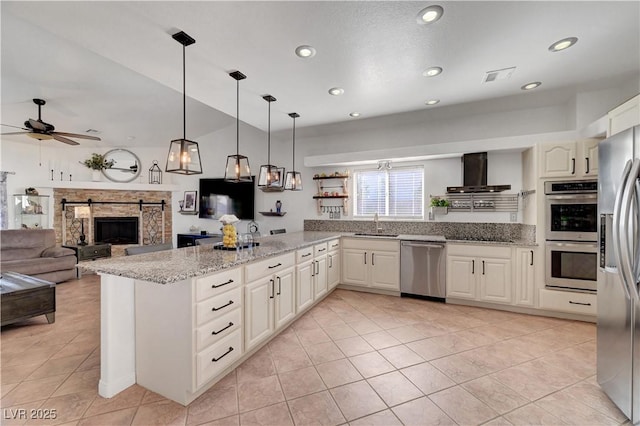 5725 N Durango Dr, Las Vegas, NV 89149 - kitchen with stainless steel appliances, wall chimney range hood, ceiling fan, a peninsula, and light tile patterned flooring