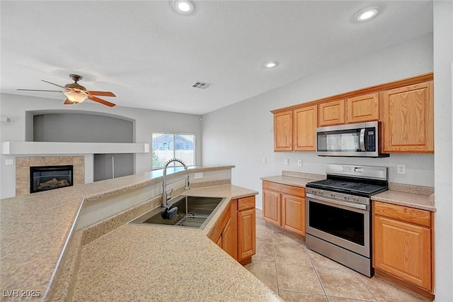1574 Ward Frontier Ln, Henderson, NV 89002 - kitchen featuring stainless steel appliances, a sink, light countertops, a ceiling fan, and light tile patterned floors