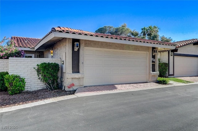 3013 Plaza De Rosa, Las Vegas, NV 89102 - view of front of house featuring stucco siding, a tiled roof, and an attached garage