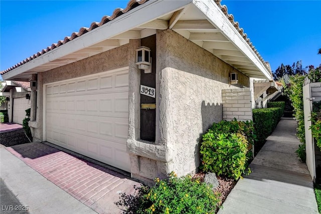 3013 Plaza De Rosa, Las Vegas, NV 89102 - view of side of property with stucco siding, a garage, and a tile roof