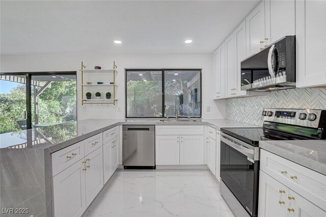 3013 Plaza De Rosa, Las Vegas, NV 89102 - kitchen featuring appliances with stainless steel finishes, a sink, light marble finish floors, backsplash, and white cabinets