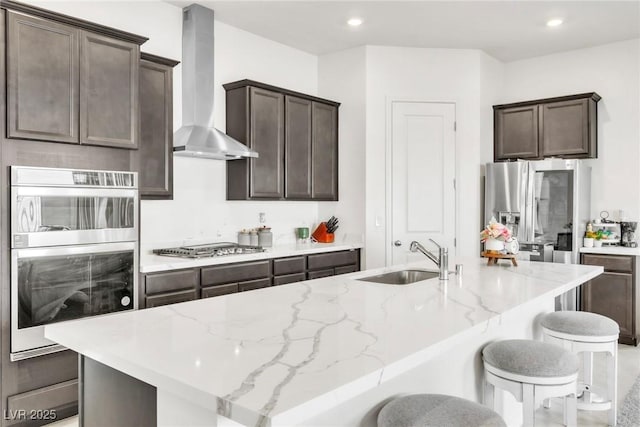 1596 Pacific Baza St, Las Vegas, NV 89138 - kitchen featuring wall chimney range hood, stainless steel appliances, a sink, dark brown cabinetry, and recessed lighting