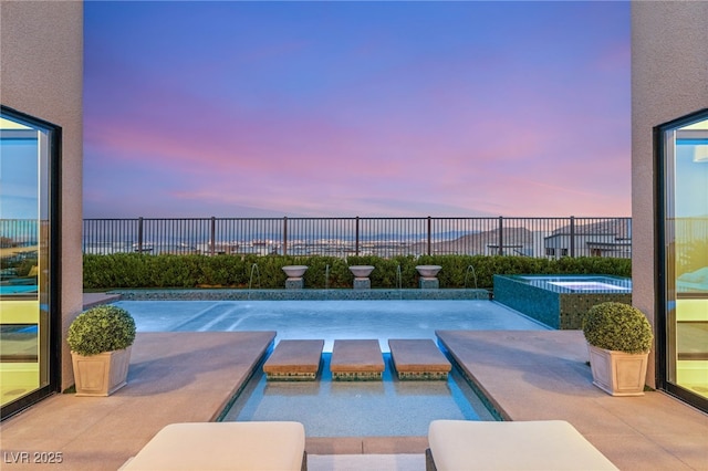 826 Bolide St, Las Vegas, NV 89138 - pool at dusk with a pool with connected hot tub and a patio area