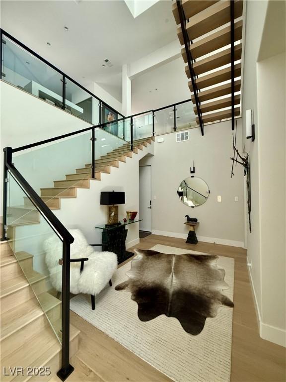358 Solitude Peak Ln, Henderson, NV 89012 - stairs with wood finished floors, baseboards, and a high ceiling
