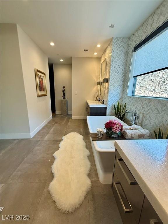 358 Solitude Peak Ln, Henderson, NV 89012 - bathroom with vanity, a freestanding bath, baseboards, recessed lighting, and concrete floors