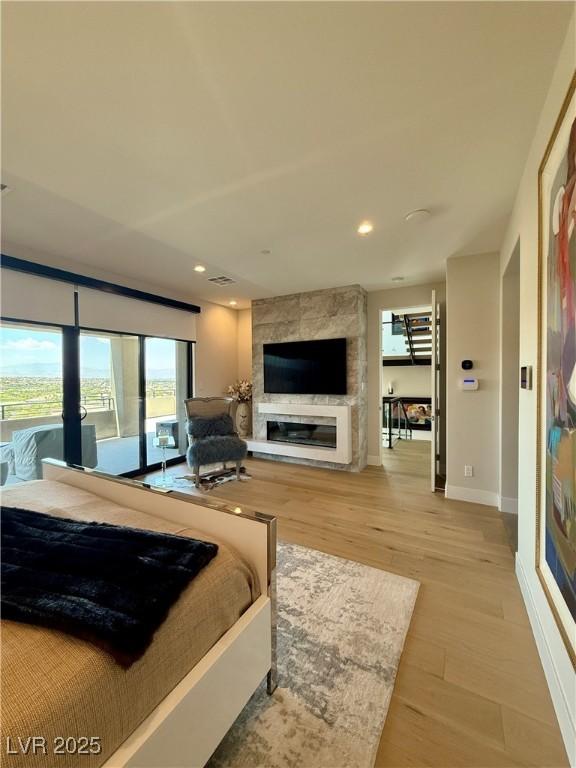 358 Solitude Peak Ln, Henderson, NV 89012 - bedroom featuring a fireplace, light wood-type flooring, recessed lighting, and baseboards