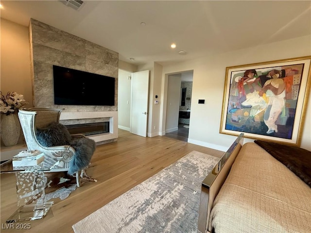 358 Solitude Peak Ln, Henderson, NV 89012 - living room featuring wood finished floors, recessed lighting, a glass covered fireplace, and baseboards