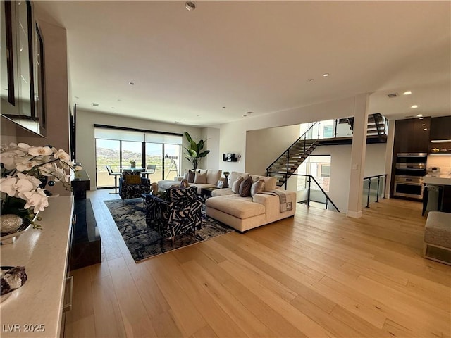 358 Solitude Peak Ln, Henderson, NV 89012 - living room featuring light wood-style flooring, stairs, and recessed lighting