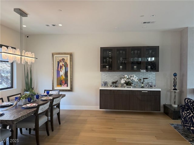 358 Solitude Peak Ln, Henderson, NV 89012 - bar area with light wood-style flooring, tasteful backsplash, baseboards, recessed lighting, and decorative light fixtures