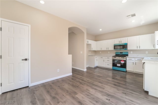 6260 Castle Kennedy St, Henderson, NV 89011 - kitchen with stainless steel appliances, arched walkways, light countertops, white cabinets, and recessed lighting