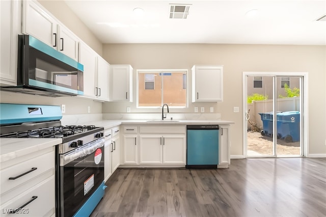 6260 Castle Kennedy St, Henderson, NV 89011 - kitchen featuring appliances with stainless steel finishes, a sink, dark wood-style flooring, and white cabinets