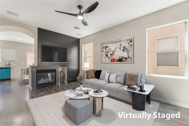 6260 Castle Kennedy St, Henderson, NV 89011 - living room featuring a ceiling fan, arched walkways, wood finished floors, and a fireplace