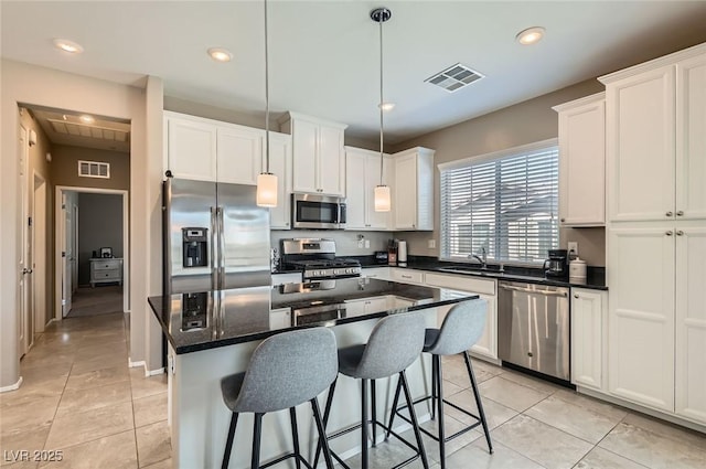 8490 Classique Ave Unit 101, Las Vegas, NV 89178 - kitchen with appliances with stainless steel finishes, white cabinets, a kitchen bar, a kitchen island, and recessed lighting