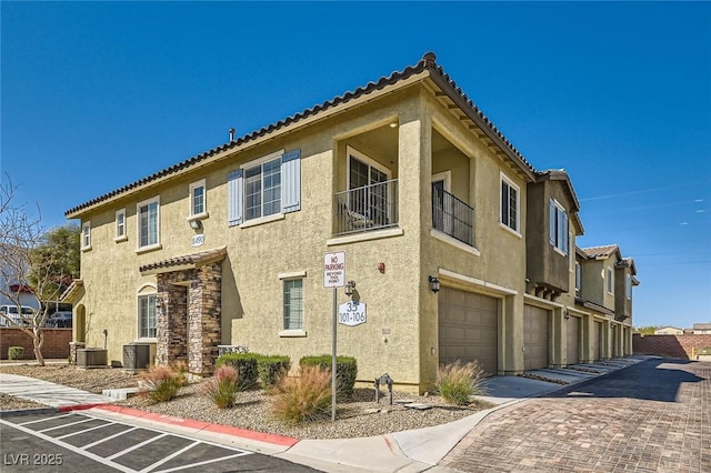 8490 Classique Ave Unit 101, Las Vegas, NV 89178 - view of building exterior featuring a garage, driveway, and central AC