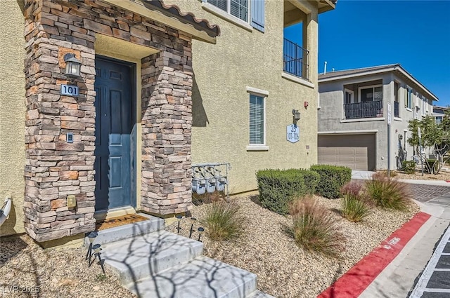 8490 Classique Ave Unit 101, Las Vegas, NV 89178 - property entrance featuring stucco siding, a balcony, a garage, and stone siding