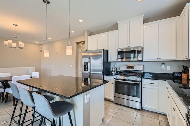 8490 Classique Ave Unit 101, Las Vegas, NV 89178 - kitchen with appliances with stainless steel finishes, light tile patterned flooring, a center island, a chandelier, and white cabinetry