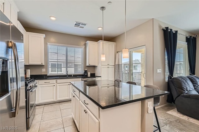 8490 Classique Ave Unit 101, Las Vegas, NV 89178 - kitchen with stainless steel appliances, open floor plan, a sink, a kitchen breakfast bar, and white cabinets