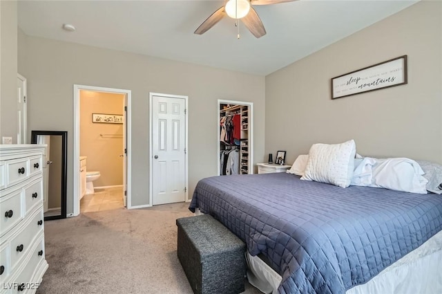 8490 Classique Ave Unit 101, Las Vegas, NV 89178 - bedroom featuring light carpet, a spacious closet, a closet, connected bathroom, and a ceiling fan