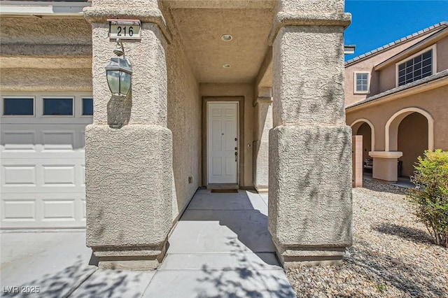 216 Sharp Edge Ave, North Las Vegas, NV 89031 - view of exterior entry with a garage and stucco siding