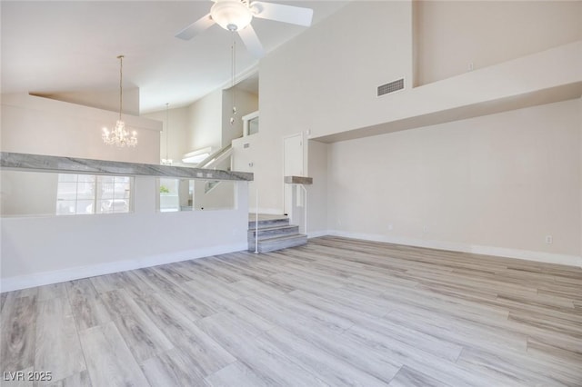 1551 Echo Falls Ave, Las Vegas, NV 89183 - unfurnished living room featuring high vaulted ceiling, stairs, a chandelier, a ceiling fan, and wood finished floors