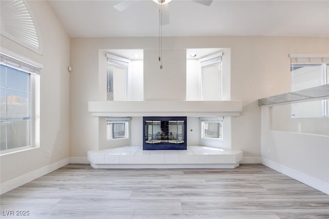 1551 Echo Falls Ave, Las Vegas, NV 89183 - unfurnished living room featuring a ceiling fan, a tile fireplace, baseboards, and wood finished floors