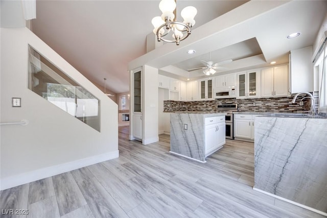 1551 Echo Falls Ave, Las Vegas, NV 89183 - kitchen featuring white microwave, range with two ovens, a sink, a tray ceiling, and a chandelier