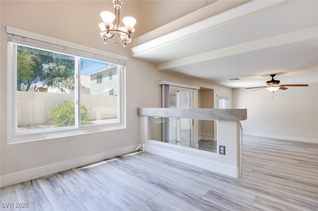 1551 Echo Falls Ave, Las Vegas, NV 89183 - unfurnished living room with a chandelier, baseboards, light wood finished floors, and a ceiling fan