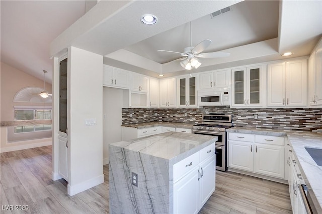 1551 Echo Falls Ave, Las Vegas, NV 89183 - kitchen featuring range with two ovens, white microwave, a ceiling fan, light stone countertops, and recessed lighting