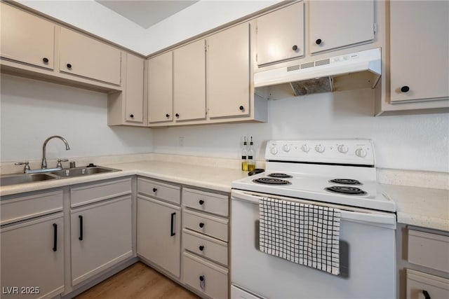 3151 Soaring Gulls Dr Unit 2121, Las Vegas, NV 89128 - kitchen with electric stove, under cabinet range hood, a sink, light countertops, and light wood-type flooring