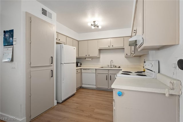 3151 Soaring Gulls Dr Unit 2121, Las Vegas, NV 89128 - kitchen with white appliances, a sink, light wood-style flooring, light countertops, and under cabinet range hood