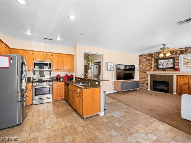 10612 Gum Tree Ct, Las Vegas, NV 89144 - kitchen featuring appliances with stainless steel finishes, a sink, open floor plan, a peninsula, and light stone finish flooring