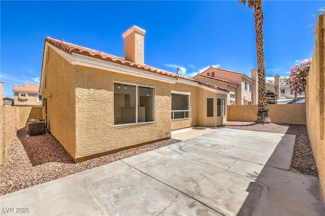 2117 Desert Peak Rd, Las Vegas, NV 89134 - back of house featuring a chimney, stucco siding, cooling unit, and a fenced backyard