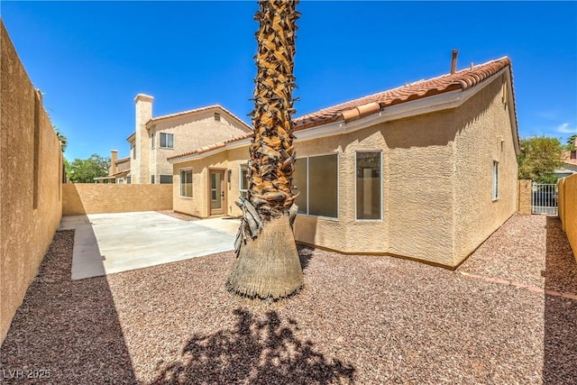 2117 Desert Peak Rd, Las Vegas, NV 89134 - rear view of house with stucco siding, a patio area, a fenced backyard, and a tile roof