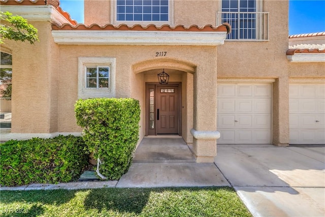 2117 Desert Peak Rd, Las Vegas, NV 89134 - view of exterior entry featuring a tiled roof, stucco siding, and driveway