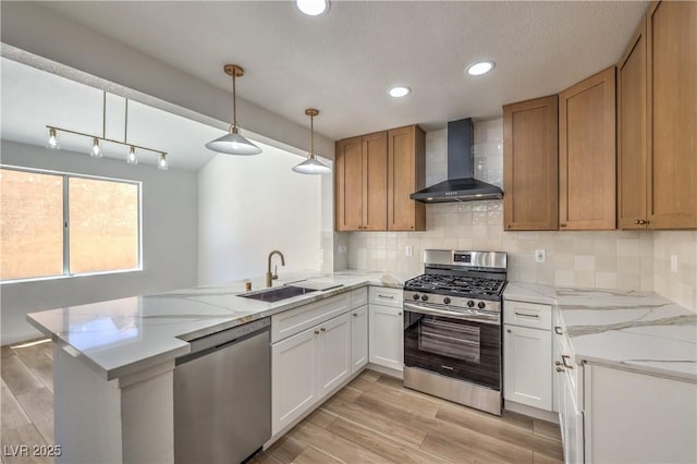2117 Desert Peak Rd, Las Vegas, NV 89134 - kitchen featuring wall chimney exhaust hood, stainless steel appliances, a sink, a peninsula, and recessed lighting