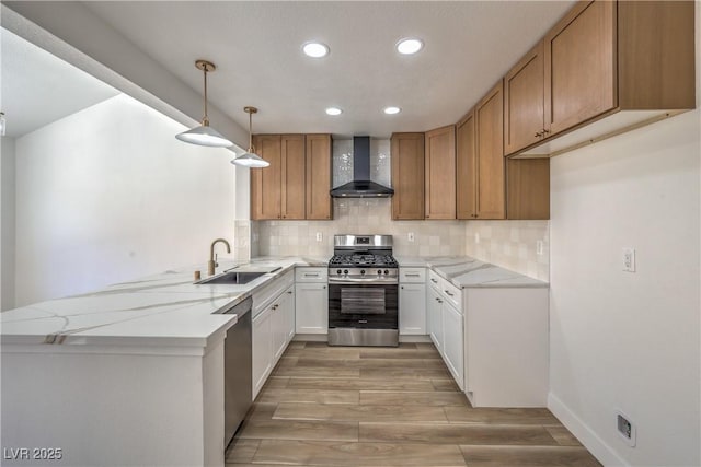 2117 Desert Peak Rd, Las Vegas, NV 89134 - kitchen with wall chimney exhaust hood, appliances with stainless steel finishes, a sink, a peninsula, and recessed lighting