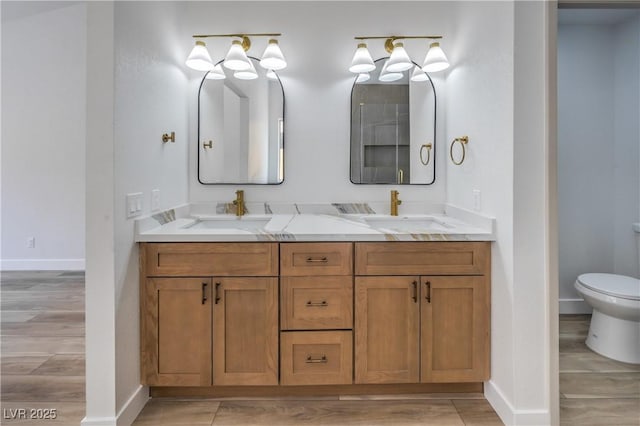 2117 Desert Peak Rd, Las Vegas, NV 89134 - full bath with double vanity, toilet, baseboards, and wood finished floors