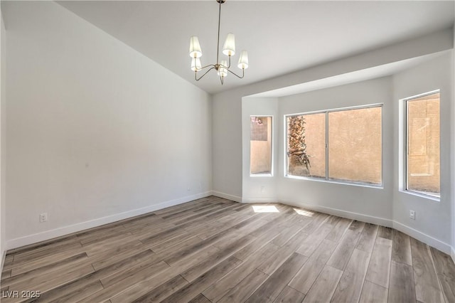 2117 Desert Peak Rd, Las Vegas, NV 89134 - empty room with a chandelier, wood finished floors, and vaulted ceiling
