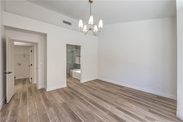 2117 Desert Peak Rd, Las Vegas, NV 89134 - unfurnished room with a chandelier, light wood-style flooring, and baseboards