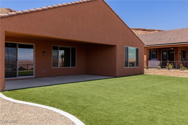 1398 Pin Cushion Rdg, Mesquite, NV 89034 - back of house featuring a patio area, stucco siding, a lawn, and a tile roof