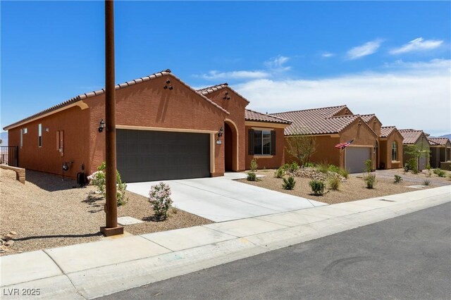 1398 Pin Cushion Rdg, Mesquite, NV 89034 - view of front of house featuring a garage, a tiled roof, driveway, and stucco siding