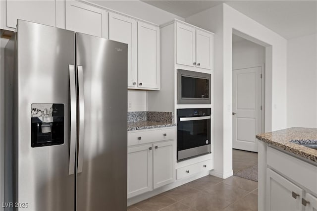1398 Pin Cushion Rdg, Mesquite, NV 89034 - kitchen with stainless steel appliances, light stone counters, tile patterned flooring, and white cabinets