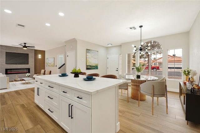 6388 Canyon Dawn Ave, Las Vegas, NV 89108 - kitchen featuring a ceiling fan, light wood-style floors, a kitchen island, white cabinets, and recessed lighting