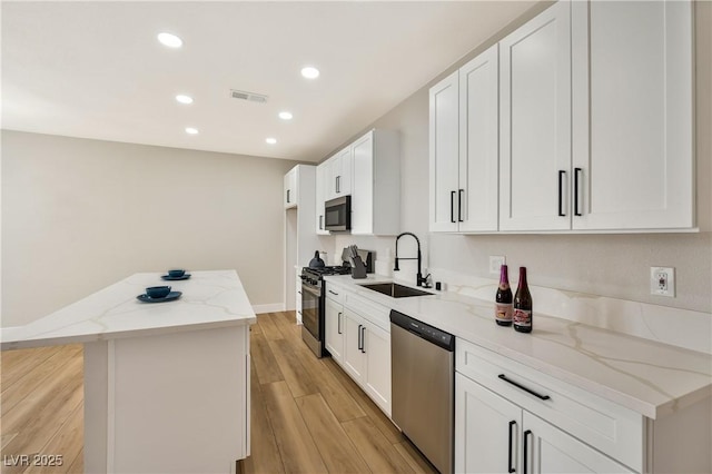 6388 Canyon Dawn Ave, Las Vegas, NV 89108 - kitchen featuring appliances with stainless steel finishes, a sink, recessed lighting, light wood-style floors, and light stone countertops