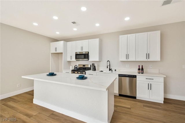 6388 Canyon Dawn Ave, Las Vegas, NV 89108 - kitchen featuring appliances with stainless steel finishes, a sink, white cabinetry, baseboards, and recessed lighting