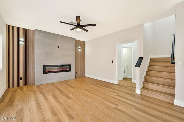 6388 Canyon Dawn Ave, Las Vegas, NV 89108 - unfurnished living room with a ceiling fan, light wood finished floors, stairs, and a tile fireplace